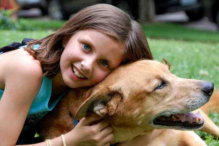 Une enfant câline son chien